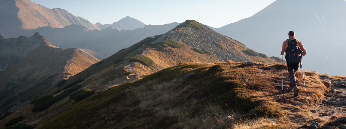 Hiker on a trail with trekking poles